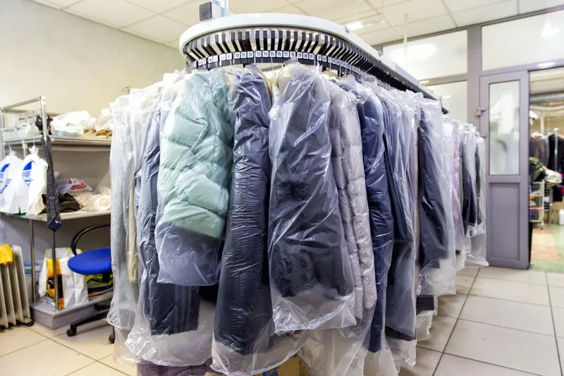 Cleaned garments bagged and hanging on a conveyor rail